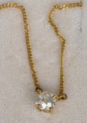 A diamond solitaire pendant
Mounted on an 18 ct gold chain, the claw set stone spreading to