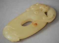 A Chinese carved jade bi disk
Surmounted with the figure of a dragon.  6 cms long. CONDITION