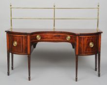 A George III mahogany inverted bow front sideboard
The shaped crossbanded top with a tubular brass