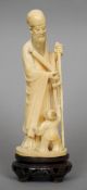 A 19th century Chinese carved ivory figural group
Formed as a sage holding a scroll, a small boy