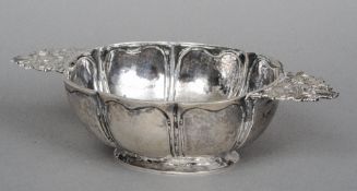 An unmarked Continental silver twin handled bowl
Of lobed oval form with pierced cast floral