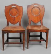 A pair of 19th century mahogany hall chairs
Each with a panelled shield back above the solid seat