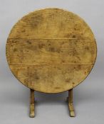 A 19th century French oak wine tasting table
Of typical hinged oval form with end trestle supports.