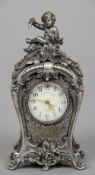 A rococo style silver plated desk clock
The top surmounted with a putto holding a dagger above the