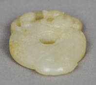 A Chinese carved jade bi disk
Surmounted with the figure of a dragon.  5.5 cm long. CONDITION