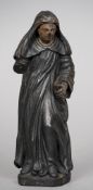 An early carved wooden figure of a monk
Dressed in typical robes holding a bible, with traces of