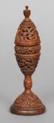 A small 19th century vase and cover carved from coquilla nuts
Of pierced scrolling form, standing on