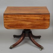 A 19th century mahogany pedestal Pembroke table
The hinged twin flap rectangular top above a