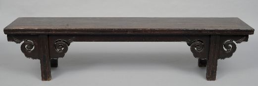 A 19th century Chinese hardwood bench
The cleated rectangular top above the scroll carved frieze,