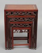 A Chinese carved hardwood nest of four tables
Each rectangular panel top above a carved frieze,