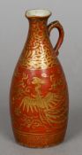 A Chinese porcelain ewer
Gilt decorated with phoenixes  on a red ground, blue painted four character