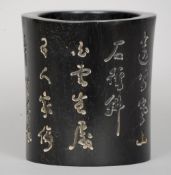 A Chinese carved ebony brush pot
The exterior with extensive calligraphic script.  14 cm high.