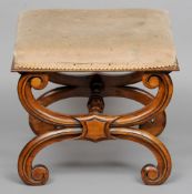 A Victorian walnut X-framed stool 
The overstuffed seat above the scroll carved X-frame base