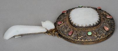 A 19th century Chinese silver gilt mounted semi-precious stone set and jade hand mirror
The verso