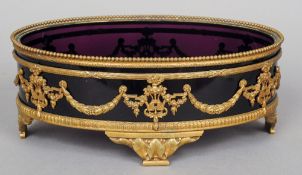 A 19th century Continental gilt bronze framed amethyst glass centre bowl
Of oval form with bead