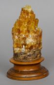 A mineral specimen
Of natural form, mounted on a turned wooden display stand.  18 cm high. CONDITION