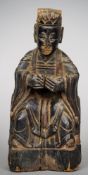 An antique Oriental carved wooden figure of a dignitary 
Modelled seated in flowing robes, the