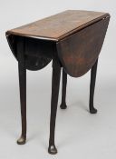 A Georgian mahogany pad foot drop leaf table
The hinged oval top above tubular legs with pad