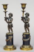 A pair of 19th century Grand Tour style bronze figural candlesticks
Each formed as a putto holding a