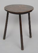 A small 18th century dark elm single plank cricket table
Of typical circular form with three