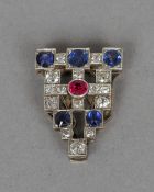 An Art Deco diamond, sapphire and ruby set white metal clip
Of pierced stepped rectangular form.