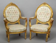 A pair of Louis XV style giltwood upholstered armchairs
Each oval padded back with carved floral