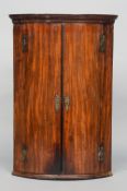 A George III mahogany bow front corner cupboard
The moulded cornice above twin doors with ornate