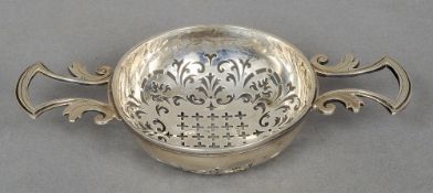 A 19th century silver twin handled lemon strainer, hallmarks indistinct
Of typical pierced form,