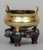 A Chinese bronze twin handled censor
Standing on a lappet carved wooden base, cast six character