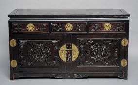 A Chinese rosewood side cabinet
The panelled rectangular top above three geometrically moulded