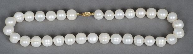 A fresh water pearl necklace
Of typical form, with a pierced 14 ct gold clasp.  41 cm long.