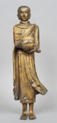 A patinated and gilt bronze figure of Buddha
Modelled standing in flowing robes holding an urn.