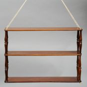 A set of 19th century mahogany "campaign" hanging shelves
The three tiers of rounded rectangular