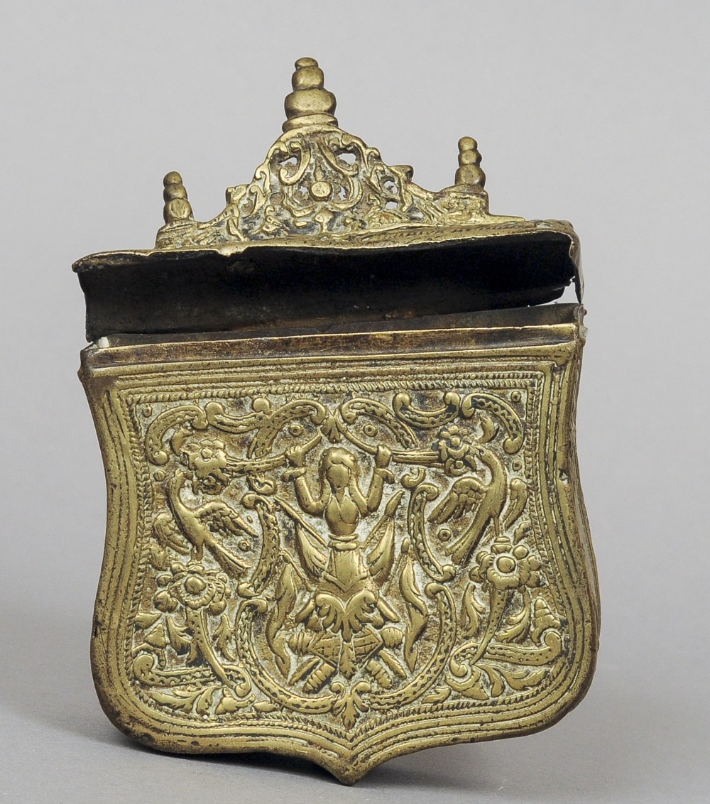 An antique Balkans brass cartridge case
The shield shaped body with embossed decoration, the