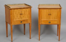 A pair of satinwood bedside commodes
Each with a three quarter pieced brass galleried top above twin