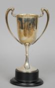 A silver twin handled trophy cup, hallmarked Sheffield 1907, maker's mark of Harry Atkin
On ebonised