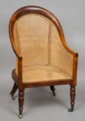 A Victorian beech and mahogany framed bergere armchair
Of deep arched form, standing on turned