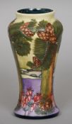 A modern Moorcroft vase
Of slender tapering form, decorated with pine trees, the underside dated 97.