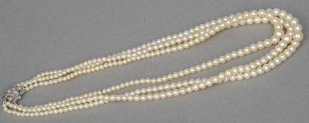 A three stand pearl necklace
Mounted with a diamond set 18 ct white gold clasp.  41 cm long.