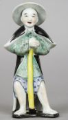 A 19th century Chinese figure of a gentleman
Wearing a hat and gown, leaning on a Dutch hoe.  25.5