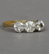 An 18 ct gold and platinum three stone diamond ring The central stone approximately 0.5 carat.