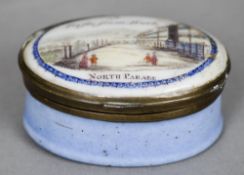 A 19th century enamel patch box
Of oval form, the hinged lid entitled A trifle from Bath, North