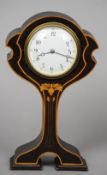 An Art Nouveau inlaid mahogany balloon clock
The white enamelled dial with Roman numerals above