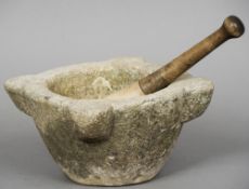 A 19th century marble mortar
Of typical four lug design; together with a wooden handled marble