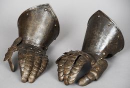 A pair of steel gauntlets
Of typical form, with chased decoration.  Each 34 cm long.  (2)