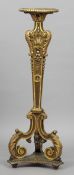 A 19th century giltwood torchere
The circular top above the acanthus capped column, standing on