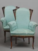 A pair of upholstered armchairs
The overstuffed backs with pierced wings above buttoned padded arms