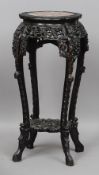 A late 19th century Chinese carved hardwood marble topped jardiniere stand
The inset shaped circular