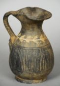 A Roman pottery ewer
With a band of floral decoration and reeded decoration, the handle with a