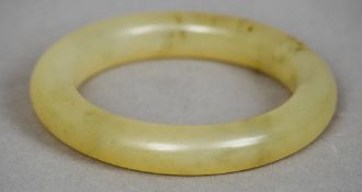 An antique Chinese mutton fat chalcedony bangle
Together with an Eastern white metal bangle,